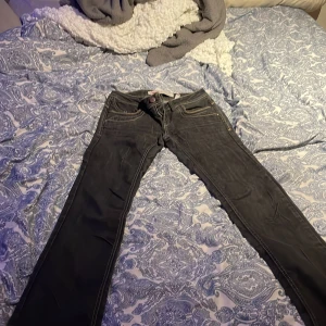 Svarta jeans från ONLY - Snygga svarta jeans från ONLY med klassisk femficksdesign och kontrastsömmar. Perfekta för en casual look. De har en knappgylf och är i en rak passform. Knapparna är borta men snygga ändå