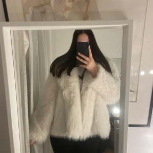 Vit pälsjacka från C.W. - Säljer en stilren vit pälsjacka från C.W. med en fluffig och lyxig känsla. Jackan har en klassisk design med långa ärmar och en mjuk finish. Perfekt för att hålla sig varm och trendig under kyliga dagar. (Den är helt oanvänd och nypris är 1299).