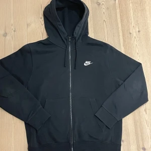 Svart Nike ziphoodie - En hoodie i bra skick som sitter bra. Är lite stor i storlek så om du har M funkar denna även bra.