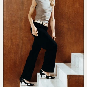 Svarta lågmidjade kostymbyxor - Snygga svarta kostymbyxor med en bootcut passform. Byxorna har en midwaist/lowwaist design. Aldrig använda, säljer då de inte passade och det kostade för mycket att frakta tillbaka😞Pris kan diskuteras! 