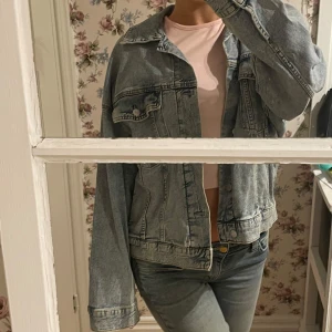Ljusblå jeansjacka H&M - Säljer en klassisk ljusblå jeansjacka med knappar framtill och två bröstfickor. Jackan har en avslappnad passform och långa ärmar. Perfekt för en casual look! Lite oversized S, jättefin och bra skick, men används tyvärr aldrig!!