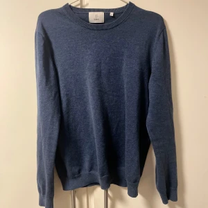 Blå tröja från Bläck - Säljer en stilren mörk blå tröja från Bläck. Den passar bra till jeans och har en bra passform. Den är använd ungefär 5 gånger så fortfarande mycket bra skick! Den passar bäst för personer runt 175-180cm+. 