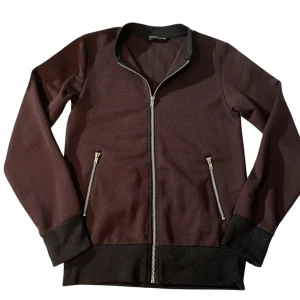 Vinröd Zip-Tröja - Säljer en riktigt snygg vinröd/brunaktig tröja i storlek XS som även passar för S. 