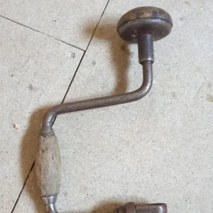 Gammaldags vevdriven borrsväng - Säljer en klassisk vevdriven borrsväng i metall med trähandtag. Perfekt för den som gillar traditionellt hantverk eller samlar på gamla verktyg. Robust design med en bekväm greppvänlig vev.