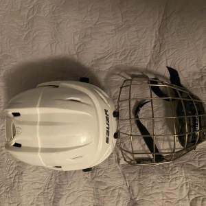 Vit hockeyhjälm Bauer Reak - Säljer Bauer hjälm då den är liten jag har bara använt den på almenhetens åkning. Perfekt för ishockeyspelare som söker säkerhet och stil.