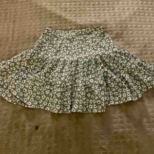 Blommig kjol med volang - Säljer en jättesöt grön blommig kjol. Sparsamt använd.