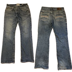 Ariat Bootcut Jeans - Feta bootcut jenas med en baggy passform. Size W32 L34 och 24cm benöppning (bild 3). Tecken på använding i framförallt hälarna med lite smuts vid höger häl (bild 4). Även mindre hål ovanför bakficka (bild 5) och liten tråd som sticker upp i höger framficka. 