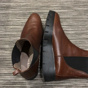 Bruna Chelsea boots i skinn - Snygga bruna Chelsea boots i skinn med elastiska sidopaneler och en robust svart sula. Perfekta för en stilren look.