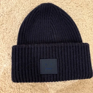 marinblå ribbad mössa från Acne Studios - lite använd men väldigt väldigt bra skick, då materialet är 100% ull. sån fin marinblå färg och är så himla varm och mysig!!! älskar den, får bara inte användning av den! nypris: ca 1500