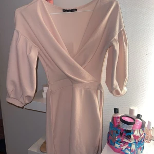 Ljusrosa klänning från Boohoo - Säljer en ljusrosa jättefin klänning som endast har använts en gång! Den har trekvartslånga ärmar och ett ”bälte” att knyta runt midjan. Perfekt till sommaren💕