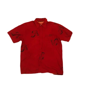 Snygg röd tröja  - Snygg röd skjorta med korta ärmar och ett coolt krabbmönster. Perfekt för en avslappnad stil med en unik touch. Skjortan har en klassisk krage och en bröstficka.             Storlek:XL Längd:75 cm Midjeöppning:60 cm Ermöppning:20 