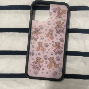 Rosa mobilskal med nallemönster - Säljer ett gulligt rosa mobilskal med söta nallar i balettkjolar och små blommor. Skalet har en svart kant som ger extra skydd och en stilren look. Perfekt för att ge din mobil en söt och unik stil! 🌸🐻