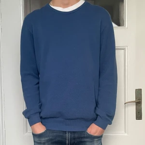 Stickad tröja från Hansen & Jacob - Säljer en stilren blå tröja från Hansen & Jacob. Tröjan har en klassisk rund halsringning och långa ärmar. Perfekt för en avslappnad look. Passar bra till jeans eller chinos. Tröjan är i stickat material och skicket är 8/10. Han på bilden är 184cm och väger 63kg. Nypriset har jag inte stenkoll på men tror det ligger runt 2000. Vid funderingar, prisförslag eller behov av fler bilder är det bara att höra av sig!