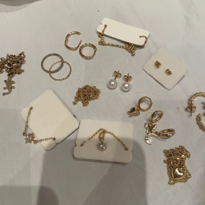 Guldiga smycken - Massa olika guldiga smycken. Säljer detta: 4 halsband, 2 armband, 2 ringar, 5 par örhängen och ett enstaka örhänge. Allt köpt samtidigt. och det mesta är inte andvänt.