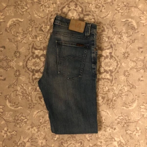 Blåa Nudie Jeans - Säljer nu dessa fräscha Nudie jeans med en snygg tvätt| finns inga defekter på jeansen och är knappt använda| De är i storlek W29 L32 och har bra passform| vid några frågor eller funderingar är det bara att höra av sig!