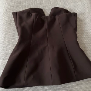 Off shoulder top - Snygg brun korsett från Zara med en stilren design. Perfekt för att ge en elegant touch till din outfit. Aldrig andvänd, säljer för den är för stor