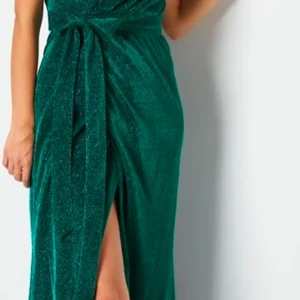 Grön glittrig klänning från bubbelroom  - Snygg grön glittrig klänning från Goddiva med en elegant slits och knytning i midjan. Den är aldrig använd med lapp kvar! 