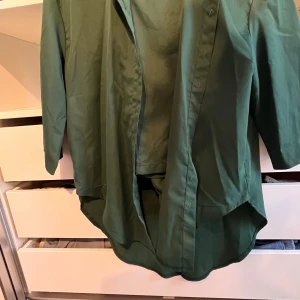 Grön skjorta - Snygg grön skjorta med klassisk krage och knappar framtill. Perfekt för en stilren look. Passar bra till både jeans och chinos.