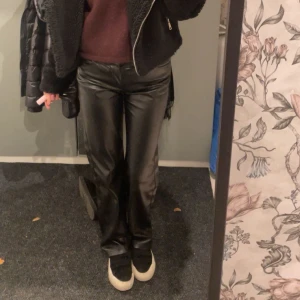 Svarta skinnbyxor - Snygga svarta skinnbyxor med en tight passform. Byxorna har en stilren design och är perfekta för en trendig look. De är lågmidjade och har en rak stil!
