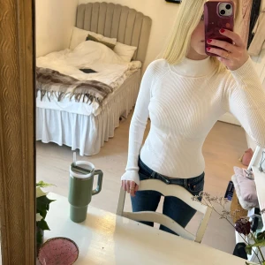 Vit ribbad polotröja S/M - Säljer en stilren vit ribbad polotröja med långa ärmar. Perfekt för en elegant och bekväm look. Passar bra till jeans eller kjol. Hör av dig vid intresse!
