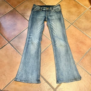 Blå bootcut jeans - Lågmidjade jeans i fint skick, förutom en något sliten lapp där bak och smått vikta kanter där bak, och en minimal fläck ❣️