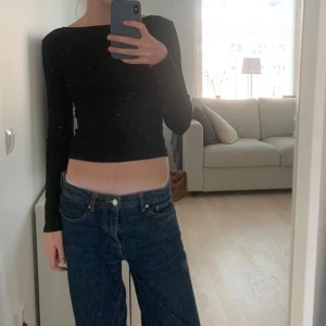 Svart långärmad topp - Snygg svart långärmad topp med en tight passform. Perfekt för en stilren look. Toppen är enkel och mångsidig, vilket gör den lätt att matcha med olika outfits.