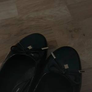 Svarta ballerinaskor från Dasia - Snygga svarta ballerinaskor från Dasia med dekorativ rosett framtill. Skorna har en elegant och klassisk design, perfekt för en stilren look. Helt nya aldrig använda! Har memory foam i innersulan 