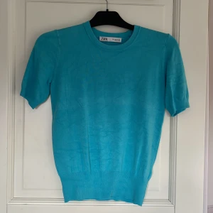 Turkos kortärmad tröja från Zara - Säljer en snygg turkos tröja från Zara med korta ärmar. Tröjan har en rund halsringning och är tillverkad i ett mjukt material som ger en skön passform. Perfekt för att få lite färg till outfiten!☺️