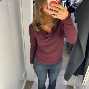 Vinröd långärmad topp - Säljer en stilren vinröd topp med långa ärmar och en draperad halsringning. Perfekt för både vardag och festligare tillställningar. 🥂💕
