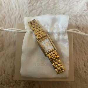 Guldfärgad klocka från Mockberg  - Nypris: 1699kr.                       Elegant guldfärgad klocka med rektangulär urtavla och romerska siffror. Klockan har ett klassiskt länkarmband som ger en tidlös stil. Perfekt för att lyfta vilken outfit som helst🥰 (KLOCKAN ÄR OMPASSAD TILL MINDRE STORLEK) säljer då jag bytt till silver! Kan även tänka mig att byta mot silver klocka🥰🥰