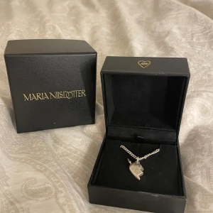 Silverfärgat halsband med delat hjärta - Säljer mitt  jättefina Maria Nilsdotter halsband då den inte kommit till användning, köpt runt april förra året men ser ut som nytt💕💕Jag kan mötas på en valfri plats i Stockholm 