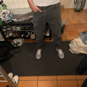 Grå cargobyxor från Bershka - Snygga grå cargobyxor från Bershka med praktiska fickor på sidorna. Perfekta för en avslappnad stil. Tillverkade i denim för en robust känsla.