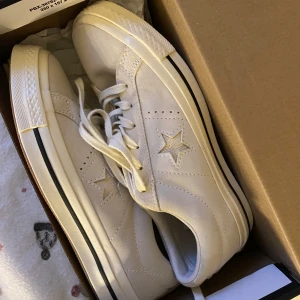 Vita sneakers från Converse - Snygga vita Converse One Star sneakers med stjärndetalj på sidan. Aldrig använda så väldigt bra skick☺️köptes för 850kr. Storlek (eur): 37.5
