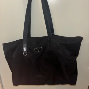 Äkta Pradaväska Canapa Tote - Köpt second hand - äkthetsbevis skickas privat. Remmen är sliten så jag kan sänka priset