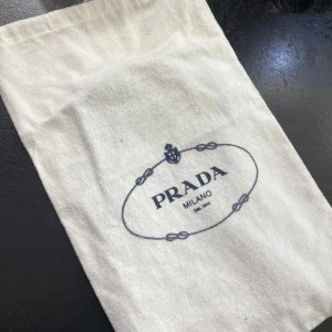 Lila axelväska från Prada - Snygg lila axelväska från Prada med silverkedja och dragkedja. Väskan har volangdetaljer och är tillverkad i skinn. Perfekt för att ge din outfit en lyxig touch. Väskan är oanvänd och det finns även äkthetsbevis från vestrie collectives! Pris går att diskutera vid snabbaffär 