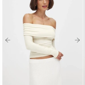 Krämfärgad offshoulder topp - Snygg krämfärgad offshoulder topp med långa ärmar. Toppen har en tight passform och är perfekt för en stilren look. Materialet ser mjukt och bekvämt ut, vilket gör den idealisk för både vardag och fest. Inga defekter. 