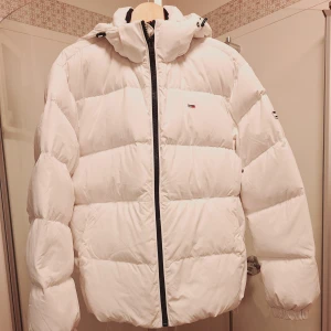 Vit dunjacka från Tommy Jeans - Säljer en snygg vit pufferjacka från Tommy Jeans. Dun. Nyskick. Stl S