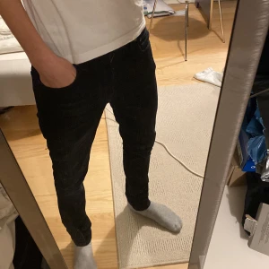 Svarta jeans från Nudie - Snygga svarta Nudie jeans med en slim passform. Perfekta för en stilren look. De har en klassisk design med fickor och knappstängning. Modellen heter Lean Dean och storleken är W29 L30✅