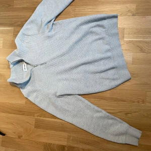 Ljusgrå ribbad tröja, halvzip - Snygg ljusgrå tröja från east west, pris kan diskuteras.