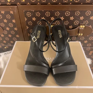 Svarta klackar från Michael Kors - Eleganta svarta sandaler från Michael Kors med smala remmar och en liten klack. Perfekta för en stilren look. Sandalerna har justerbara spännen i guld för en bekväm passform. Väldigt fina och nypris på ungefär 2000kr så bra pris.
