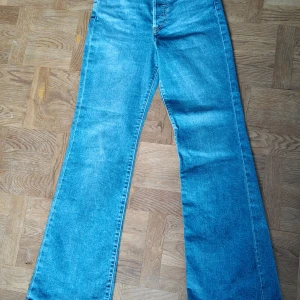 Blå Levi's Ribcage Bootcut Jeans 28 - Supersnygga Levi's Ribcage Bootcut jeans vida ben.   Storlek;  W28 L 31                          I mycket bra skick.                                          Längd 111,50 cm, innerben 81 cm, vidd ben längst ner 26 cm, gren framtill 31 cm