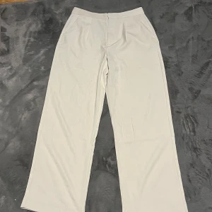 Beige kostymbyxor från lager 157 - Snygga beige kostymbyxor från lager 157 i storlek M. De har en rak passform och är perfekta för en stilren look. Säljer dem då dem är lite dör tighta i midjan och då bara blivit liggandes i garderoben. Kom privat för fler bilder och frågor!