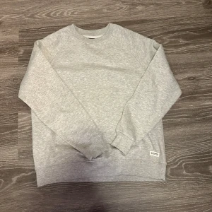 Grå sweatshirt från lager  157 - Säljer en stilren grå sweatshirt från lager 157 i storlek S. Tröjan har en klassisk design med rund hals och långa ärmar. Perfekt för en avslappnad look.