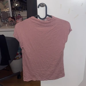 Rosa t-shirt - Säljer en enkel och bekväm rosa t-shirt med korta ärmar. Perfekt för vardagsbruk och lätt att matcha med olika outfits. Storlek 150 men jag har vanliga fall xs-s 