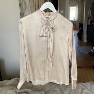 Satinblus med knyt  - Fin blus, knappt använd. Skulle säga att blusen även passar en S. 