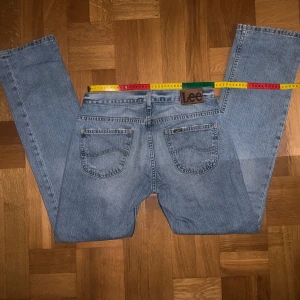 Blå jeans från Lee - Säljer dessa supersnygga ljusblå jeans från Lee som tyvärr är för stora för mig som har storlek S. De har en rak/bootcut passform och är i bra skick, något slitna längst ned och på fickorna vilket jag bara tycker är snyggt, se bilder. Står ingen storlek i dem men jag skulle gissa att de passar någon med M/L. Midjemåttet rakt över är ca 39 cm! Skriv gärna vid frågor💗