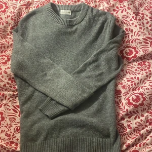 Grå tröja från These Glory Days - Säljer en stilren grå tröja från These Glory Days i storlek medium. Tröjan har en klassisk rund halsringning och ribbade muddar vid ärmslut och nederkant. Perfekt för en avslappnad och snygg look.