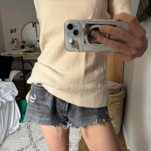 Grå jeansshorts med slitningar - Snygga grå jeansshorts med slitna detaljer och fransig kant. Perfekta för en avslappnad stil. De har en elastisk midja för extra komfort.