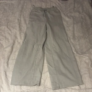 Ljus gröna mjukisbyxor från H&M - Säljer ett par bekväma ljus gröna mjukisbyxor från H&M. Byxorna har en elastisk midja med dragsko och raka ben för en avslappnad passform. Dom är uppsydda! Jag är 160 cm lång och dom slutar runt fotknölarna på mej. 