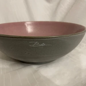 Skål från Bitz i grått och rosa - Elegant skål från Bitz med en stilren grå utsida och en vacker rosa insida. Perfekt för servering eller som en dekorativ detalj i hemmet. Skålen har en rund form och en subtil glansig finish. Diameter 30cm, höjd 10cm. Nypris: 699:-
